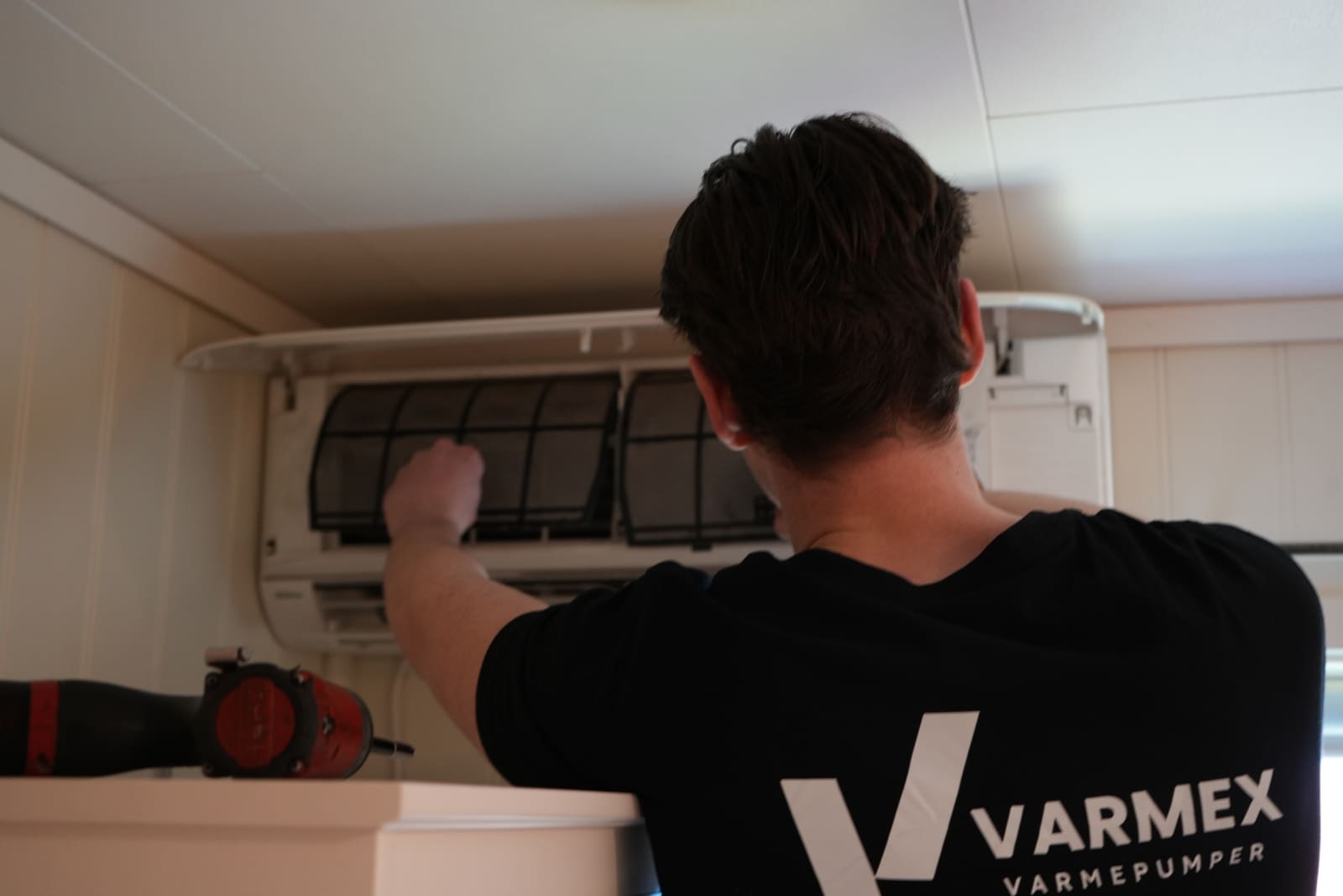 Varmex-tekniker tar service på innedelen til en varmepumpe